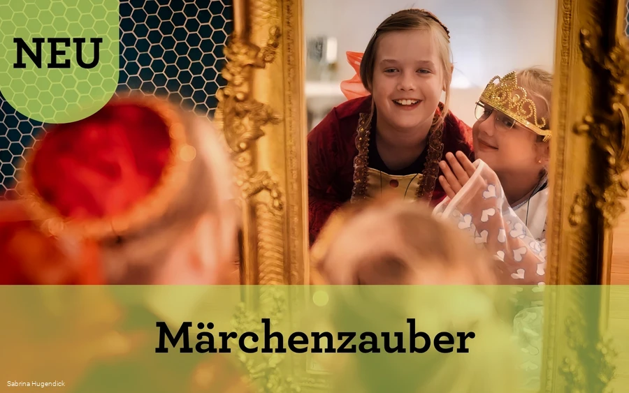 Kinderworkshop Märchenführung (Verweis) Zwei Mädchen in Prinzessinnenkleidern schauen lachend in einen golden umrandeten Spiegel